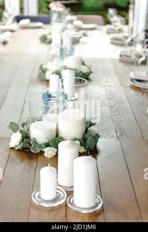 Beautiful outdoor wedding decoration in city. Candles, accessories, bouquets and glasses on table, flat lay, free space, nobody. Stock Photo