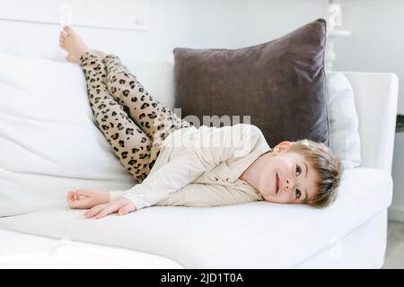 Smiling boy lying on sofa Stock Photo