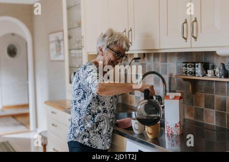 Senior woman in kitchen preparing coffee Stock Photo