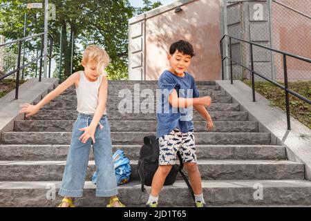 Children dancing on stairs in summer Stock Photo