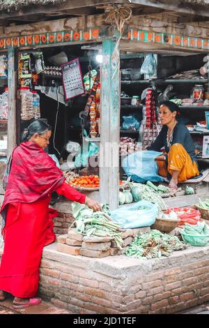 Women selling goods such as vegetables in her little shop in bhaktapur, a Newari city in the Kathmandu valley Stock Photo