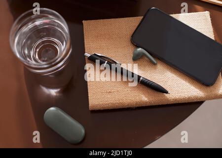 Smartphone and earbuds on notebook Stock Photo