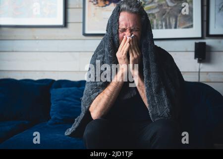 Ill man sitting on sofa Stock Photo