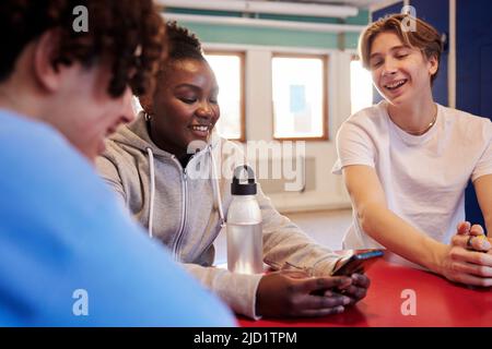 Teenagers talking in locker room Stock Photo