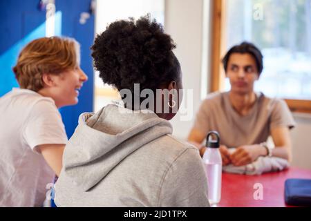 Teenagers talking in locker room Stock Photo