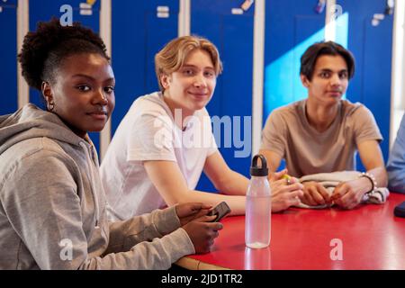 Teenagers sitting in locker room Stock Photo