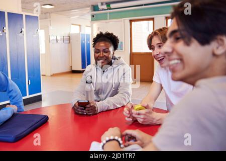 Teenagers talking in locker room Stock Photo