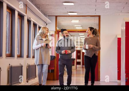 Co-workers talking at corridor Stock Photo