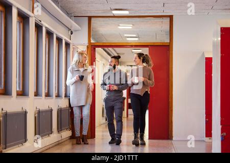 Co-workers talking at corridor Stock Photo