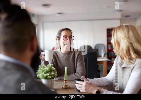 Co-workers talking during coffee break Stock Photo