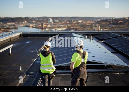 Workers standing on roof Stock Photo