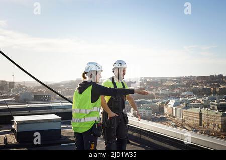 Workers standing on roof Stock Photo