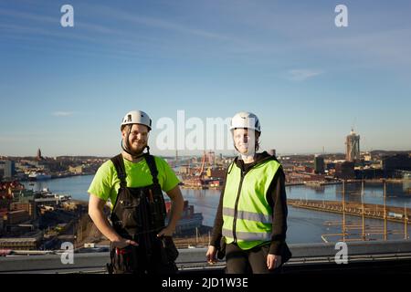 Workers standing on roof Stock Photo