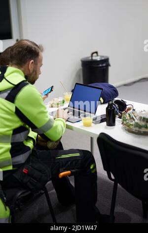 Man using laptop in canteen Stock Photo