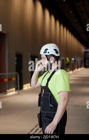 Worker using cell phone at building site Stock Photo