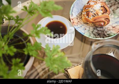 Cup of tea and cinnamon bun on table Stock Photo