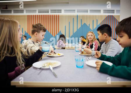 Children having lunch in cafeteria Stock Photo