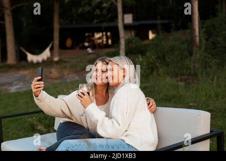 Female friends taking selfie on bench Stock Photo