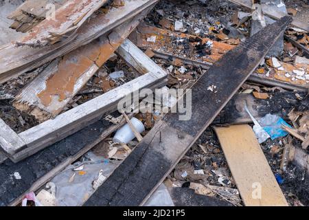 Garbage background from old burnt wooden boards, bricks, plastic. Garbage after the destruction of the house. Waste recycling. Stock Photo