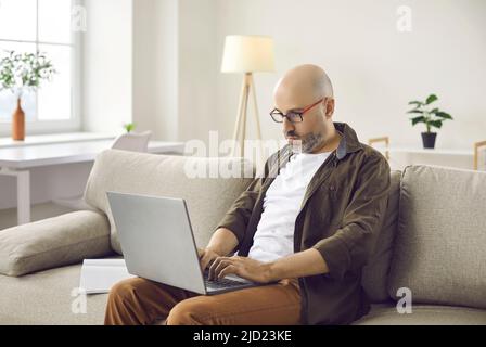Portrait of confident serious and focused casual businessman working remotely at home. Stock Photo