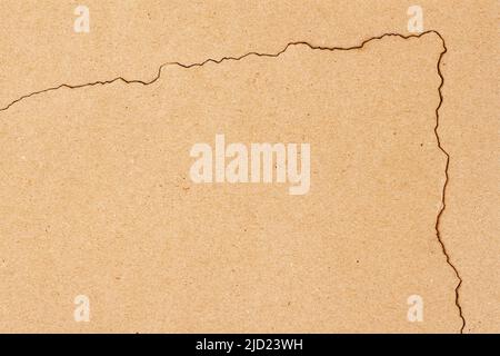Corner of burnt piece of kraft paper on craft background close-up, copy space Stock Photo
