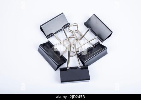 An image of black paper clips on white Stock Photo