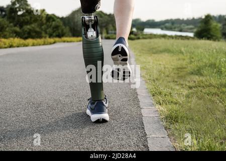Sport man with prosthetic leg running training outdoor - Fitness and disability concept - Focus on prosthesis Stock Photo