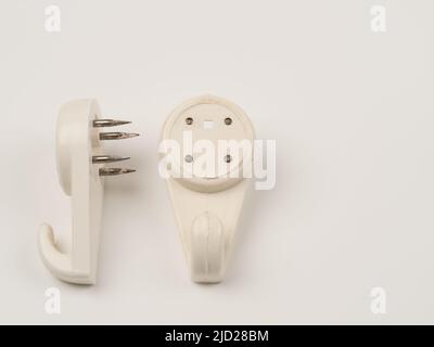 close up flat lay image of a pair of single hook nylon plastic   wall mounted picture hooks Stock Photo