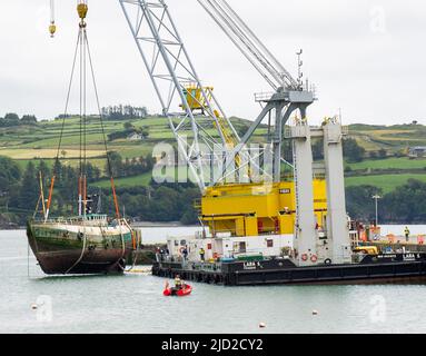 Shipwreck being lifted onto Lara 1 floating crane ship deck keelbeg pier Union Hall, West Cork, Ireland Stock Photo