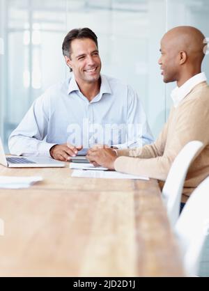 Discussing the project budget. Two businessman having a discussion in the boardroom at the office. Stock Photo