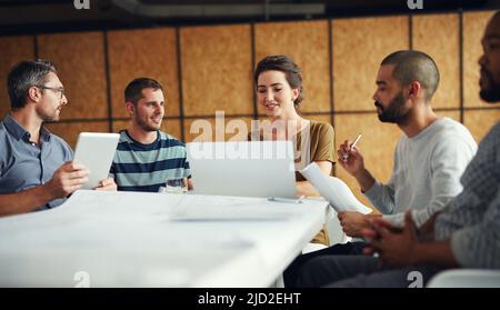 Theyll come up with the best way forward. Shot of a group of coworkers having a meeting in an open plan office. Stock Photo