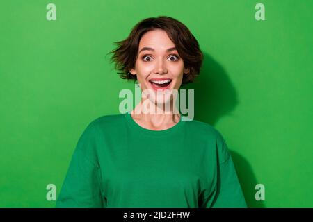 Photo of sweet impressed woman wear casual t-shirt smiling open mouth isolated green color background Stock Photo