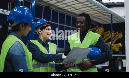 Team of multiracial engineers working in robotic factory monitoring the project on laptop - Tech industry concept Stock Photo