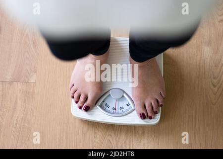 Low Section Of A Person Standing On Weighing Scale Stock Photo