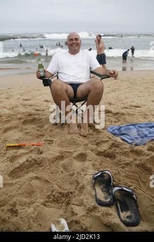 Tourist on beach drinking beer, Umfolozi Beach, KwaZulu Natal, South Africa. Stock Photo