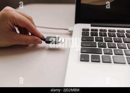 Female hand put USB adapter to copy file by laptop Stock Photo