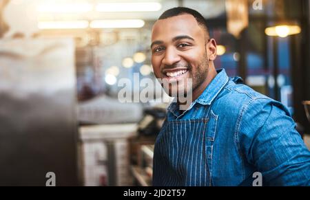 My service is even better than my smile. Cropped portrait of a handsome young man standing in his coffee shop. Stock Photo