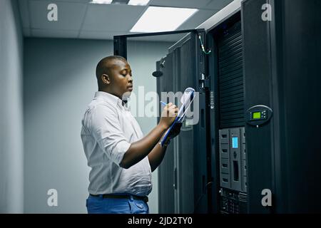 System administration done by a specialist. Shot of an IT technician doing inspections in a data center. Stock Photo