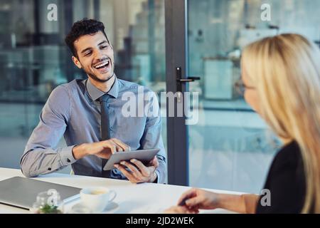 Team rapport, a must have for effective collaborations. Shot of a young businessman and businesswoman having a discussion in the boardroom of a modern Stock Photo