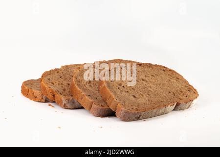 Slices grain bread isolated on bright background. Close up view. Stock Photo