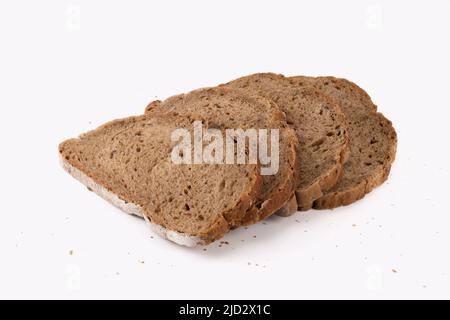 Slices of bread with crumbs isolated on bright background. Wholegrain bread. Close up view. Stock Photo