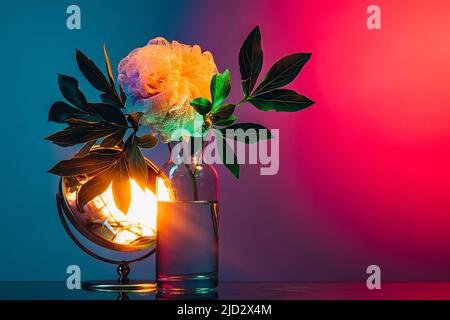 Creative floral composition over dark colored background in neon light. Concept of art, floristry, decorations, creativity, decor Stock Photo