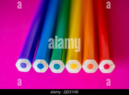 Six colored pencils seen from the top on pink cardboard that represent the colors of the rainbow and the flag of lgtbi rights Stock Photo