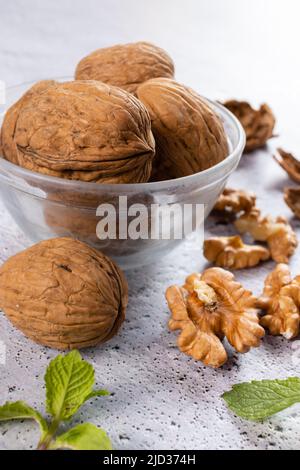 Selective focus on walnuts in a bowl and kernels on white background Stock Photo