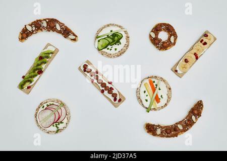 Rice cake and crispbreads with cream cheese and vegetables on white background Stock Photo
