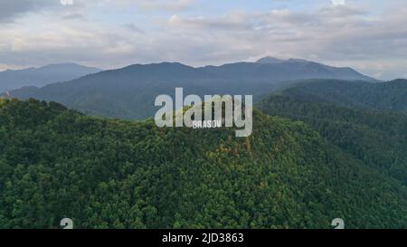 Drone top aerial view of Brasov town sign in Transylvania, Romania with forests and mountains Stock Photo