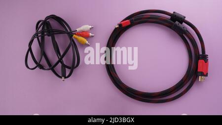 Top view of HDMI cable Vs analog RCA connector on purple background Stock Photo