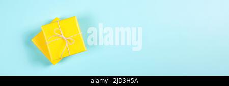 Two yellow gift boxes on blue background. Banner for website. Stock Photo