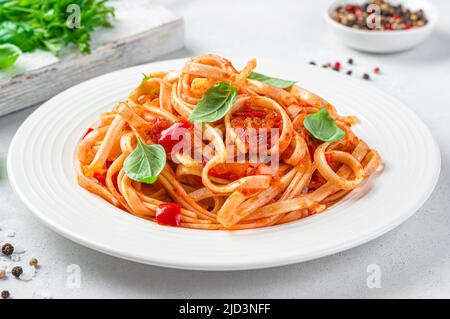 Pasta with tomatoes, pepper and garlic on a light gray background, close-up. Stock Photo