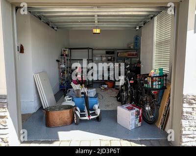 Orlando, FL USA - March 3, 2022: An unorganized garage filled with a lot of stuff in a neighborhood. Stock Photo